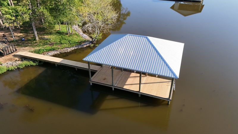 Aerial view of a metal-roof covered dock and its walkway to shore
