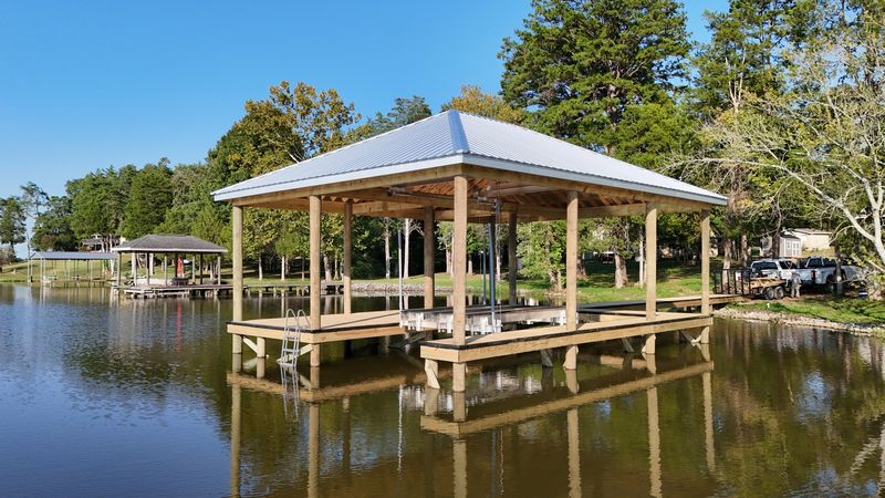 Covered fixed dock with a metal hip roof and open timber framing