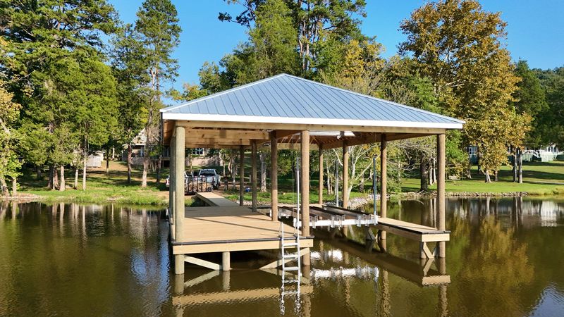 Covered fixed dock with a metal roof, boat lift and swim ladder