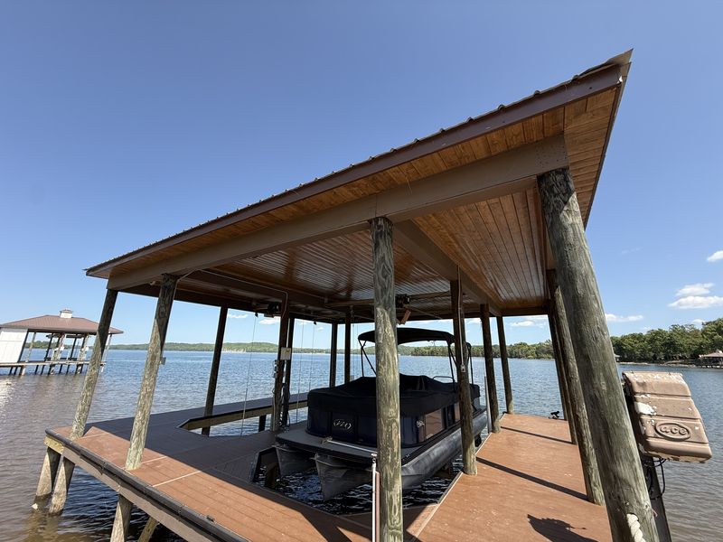 Stained wood ceiling over a pontoon on a boat lift in a covered slip