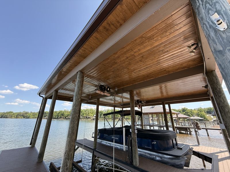 Tongue-and-groove wood ceiling and round pilings over a covered pontoon slip