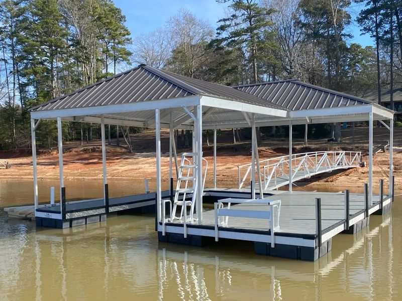 Covered floating dock with a metal hip roof and an aluminum gangway to shore