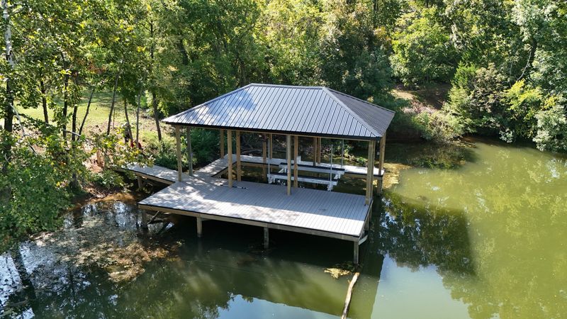 Covered dock with a dark metal roof and a wide gray composite deck