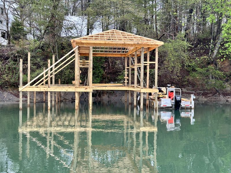 Boathouse under construction — roof framing on pilings over a Tennessee lake
