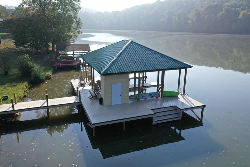 Custom fixed boathouse with a metal roof on a Tennessee lake