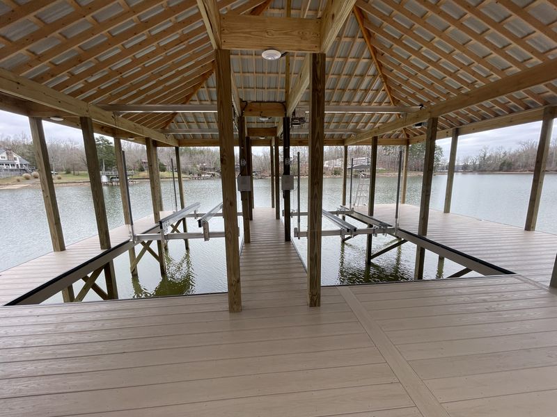 Twin Tide Tamer cable lifts installed inside a Blue Horizon covered boathouse - the go-to fixed-dock lift