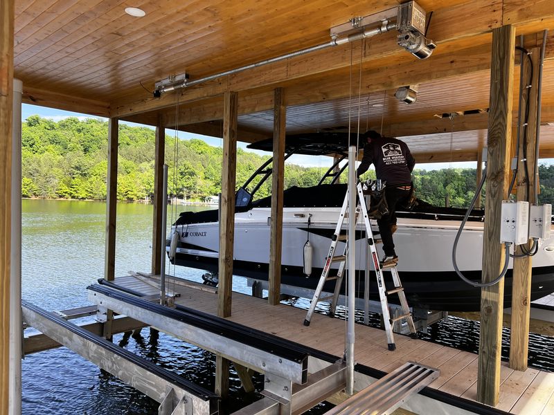 Tide Tamer cable boat lift installed in a covered boathouse with a Cobalt wakeboat